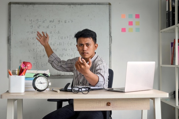 Молодой азиатский учитель дает ученикам возможность ответить на вопрос