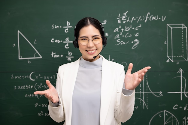 Young asian teacher woman wearing headset speaking video
conference with student female teacher training the mathematics in
classroom blackboard online course