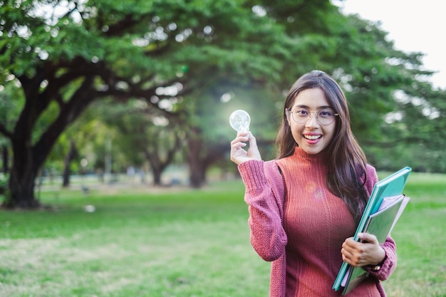 Молодой азиатский студент-подросток держит лампу для вдохновения и концепции образования