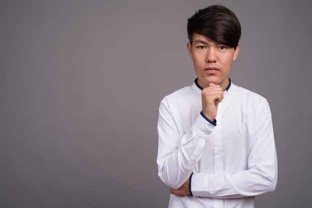 young Asian teenage boy wearing smart casual clothes 