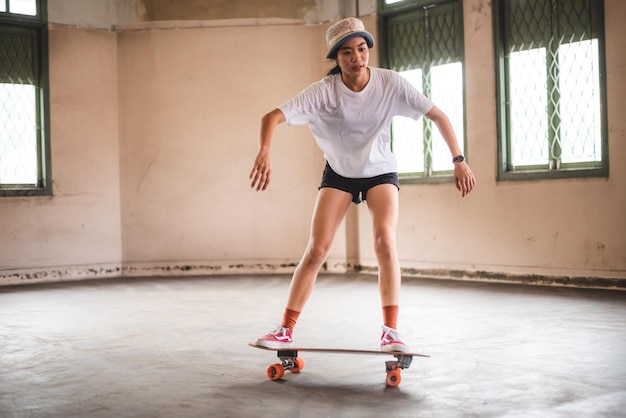 Young Asian teenage girl playing skateboard urban sport happy and fun lifestyle with skateboarding