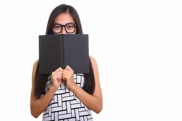 Foto giovane ragazza adolescente asiatica del nerd che si nasconde dietro il libro