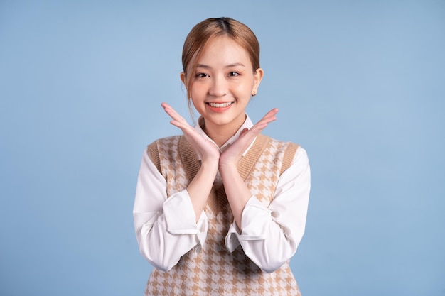 Young Asian teenager on blue background