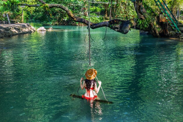 Photo young asian tourists enjoying the blue lagoon in vang vieng laos