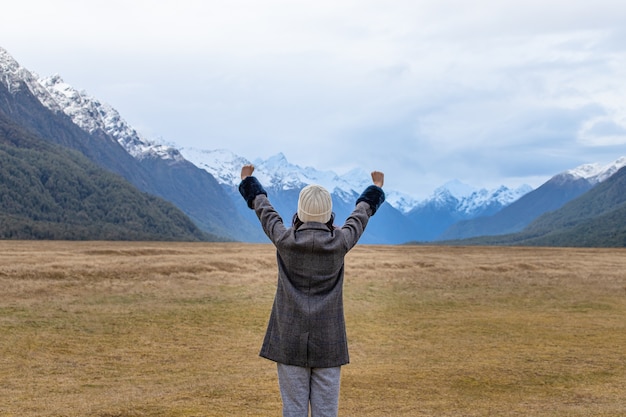 Young Asian traveler celebrating success at Eglinton Valley, Te anua, South Island, New Zealand