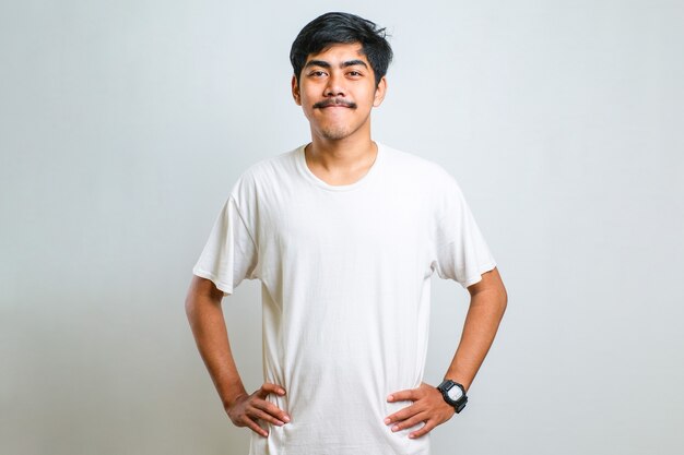 Young asian traveler man confident keeping hands on hips over white background