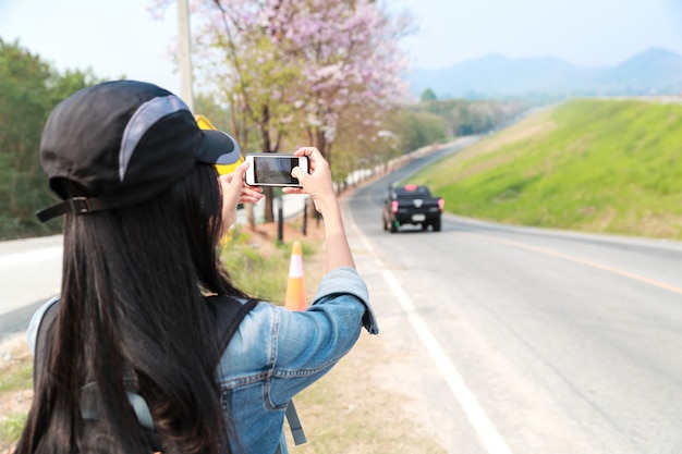 Young asian traveler using camera and taking picture while traveling on holiday vacation