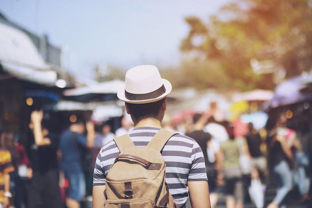 Young Asian traveling backpacker in Khaosan Road outdoor market in Bangkok, Thailand