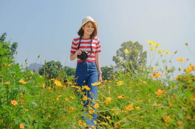 꽃 정원 여행 카메라를 들고 젊은 아시아 여행 여성