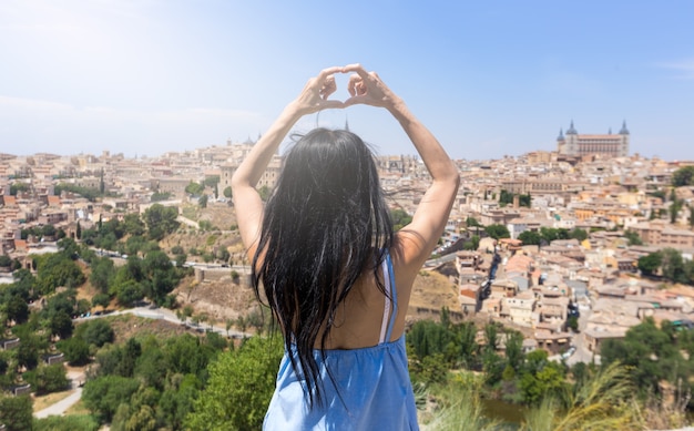 Giovane viaggiatore asiatico che fa simbolo del cuore della mano a toledo