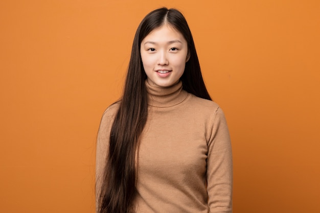 Young asian woman against an orange background