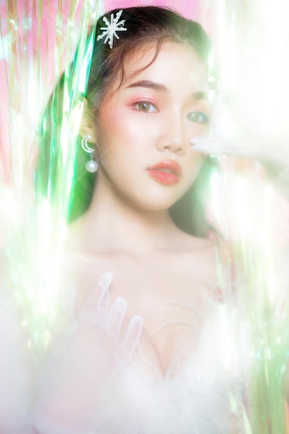 Young Asian woman beautiful face wear glamour dress poses surround by a rainbow curtain party