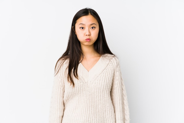 Photo young asian woman blows cheeks, has tired expression