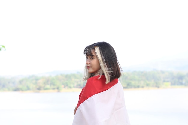 インドネシアの旗を運ぶアジアの若い女性