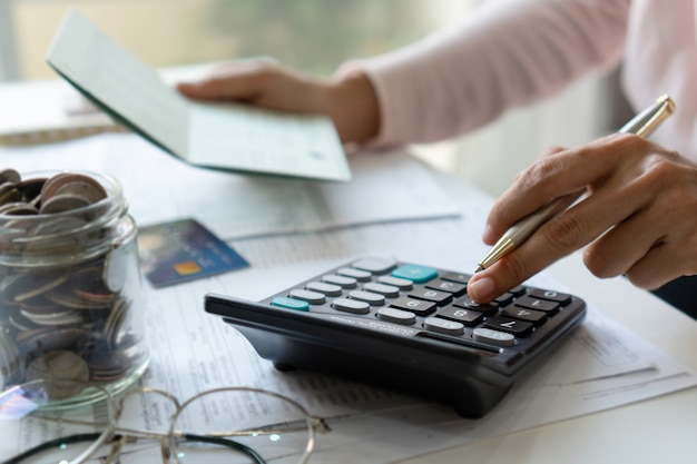 Young asian woman checking bills, taxes, bank account balance and calculating credit card expenses. Family expenses concept.