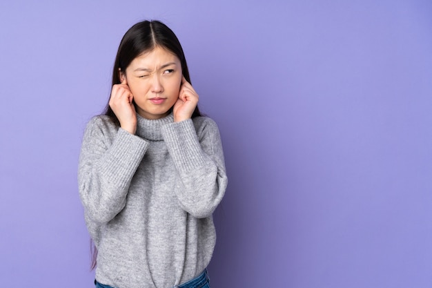 Young asian woman covering ears