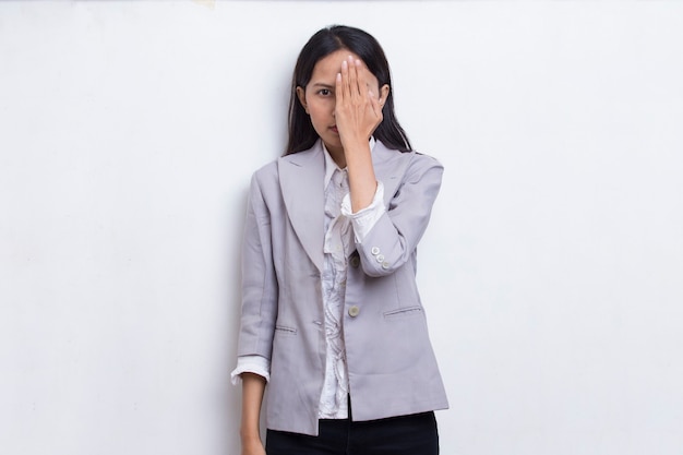 Young asian woman covering one eye with hand isolated on white background