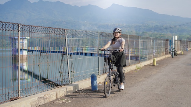 夏にサイクリングアジアの若い女性