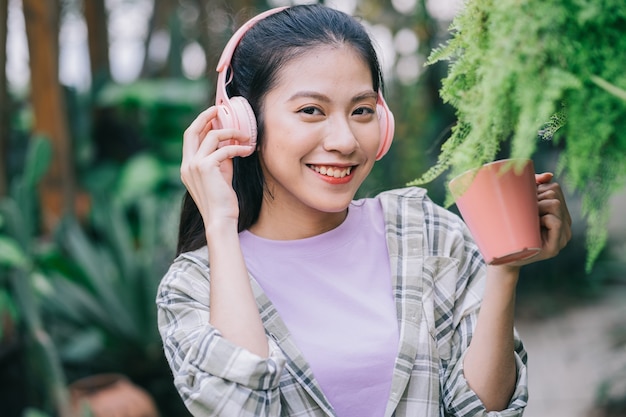 Giovane donna asiatica che beve il tè in giardino