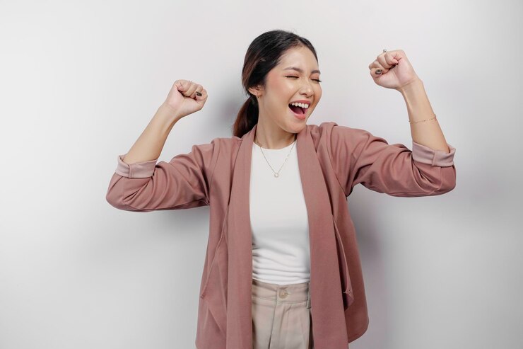 Photo 白い背景に隔離されたカーディガンを着た幸せな成功した表情の若いアジア人女性従業員