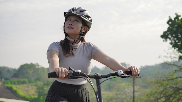 Young asian woman enjoying cycling and scenery in summer morning