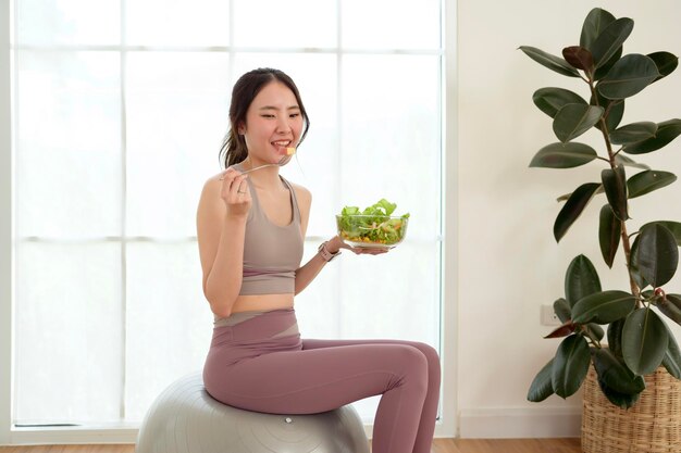 Photo young asian woman in enjoying eating healthy food after work out