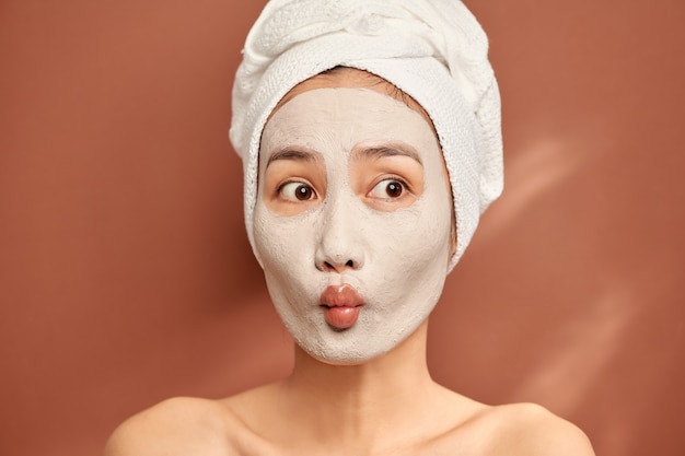 Young Asian woman enjoying of a facial mask treatment.