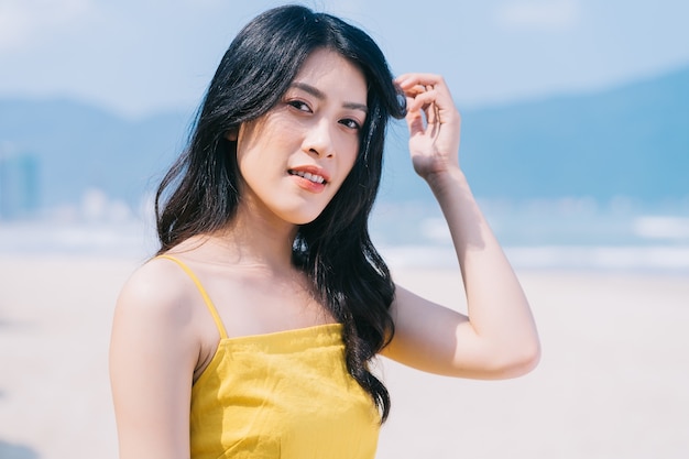 해변에서 여름 휴가를 즐기는 젊은 아시아 여성