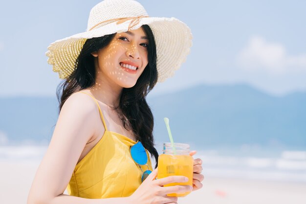 ビーチで夏休みを楽しんでいる若いアジアの女性