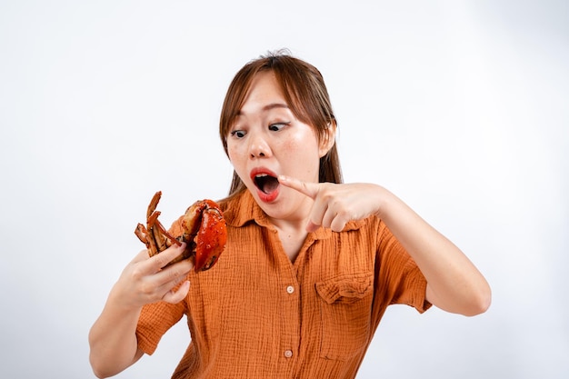 젊은 아시아 여성은 파당 소스와 함께 해산물 게를 먹는 것을 즐깁니다.
