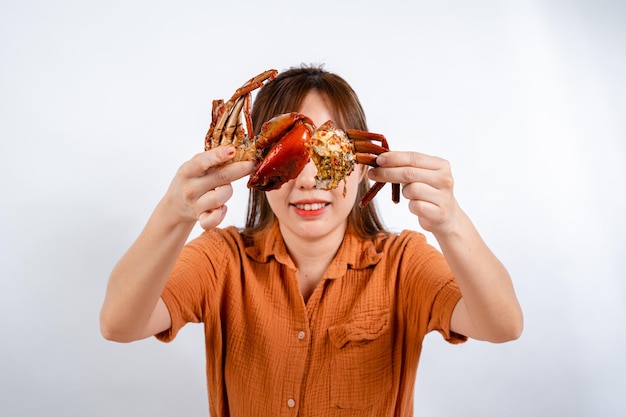 Photo young asian woman enjoys eating seafood crab with padang sauce