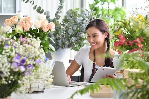 若いアジアの女性起業家/ショップオーナー/小さなフラワーショップビジネスの花屋