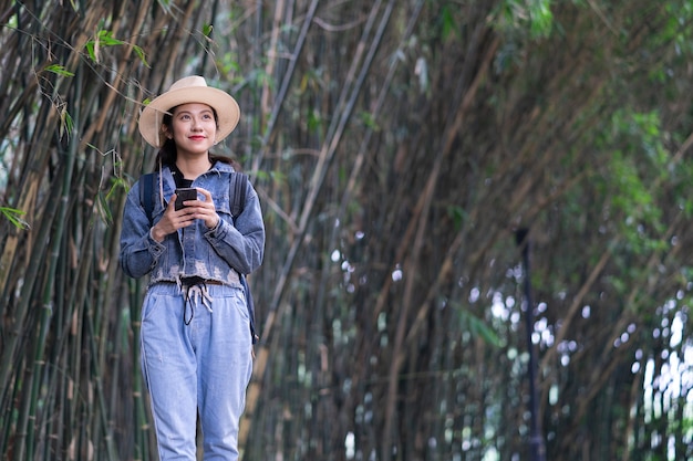 La giovane donna asiatica esplora la foresta in vacanza