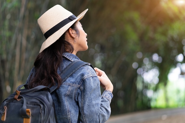 Young Asian woman explores the forest on holiday