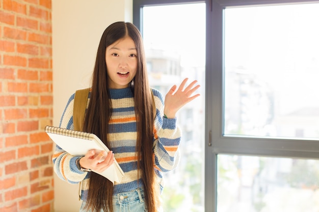 행복하고 놀라움과 쾌활한 느낌, 긍정적 인 태도로 웃고, 해결책이나 아이디어를 실현하는 젊은 아시아 여성