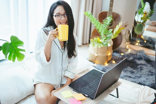 젊은 아시아 여성 프리랜서 작업 비즈니스는 집에서 노트북으로 작업하며 가정 개념에서 일합니다.