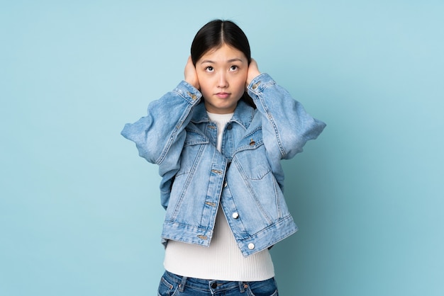 Young asian woman frustrated and covering ears