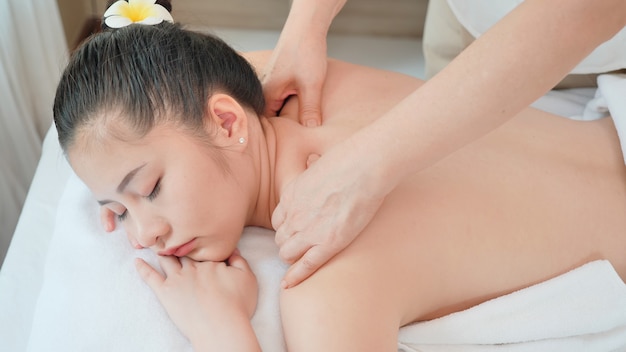 Фото Молодая азиатская женщина получая расслабляющий массаж масла на салоне курорта красоты. массаж для здоровья