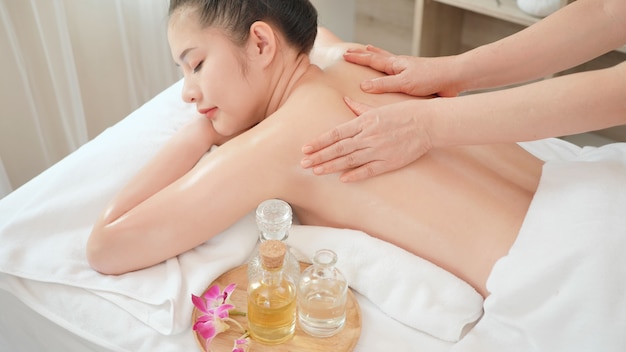 Фото Молодая азиатская женщина получая расслабляющий массаж масла на салоне курорта красоты. массаж для здоровья