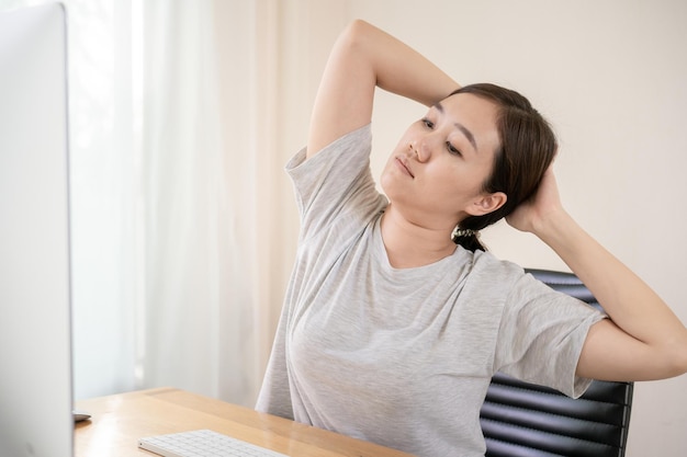 Young asian woman having an office syndrome health problem\
after overworking for a long time. asian working woman suffer\
injury at her neck. discomfort work place make people\
uncomfortable.