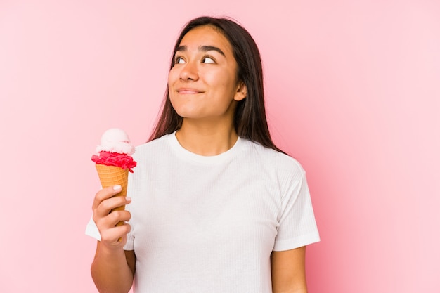 Young asian woman holding a ice cream dreaming of achieving goals and purposes