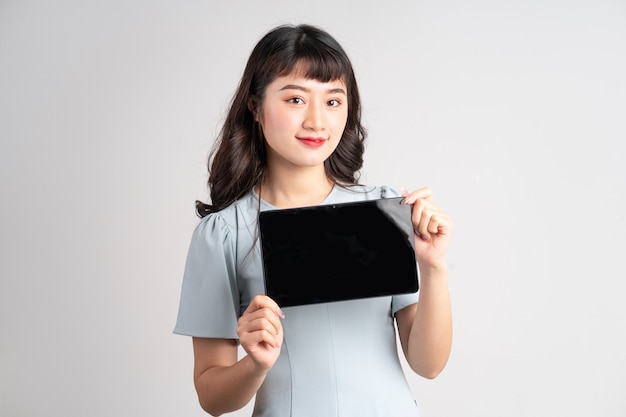 Молодая азиатская женщина, держащая планшет на белом