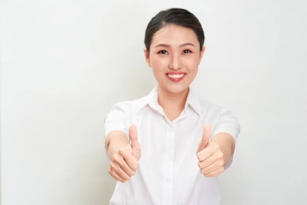 Young asian woman is showing thumb up gesture using both hands.