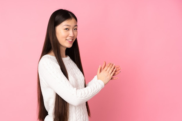 Young asian woman over isolated applauding