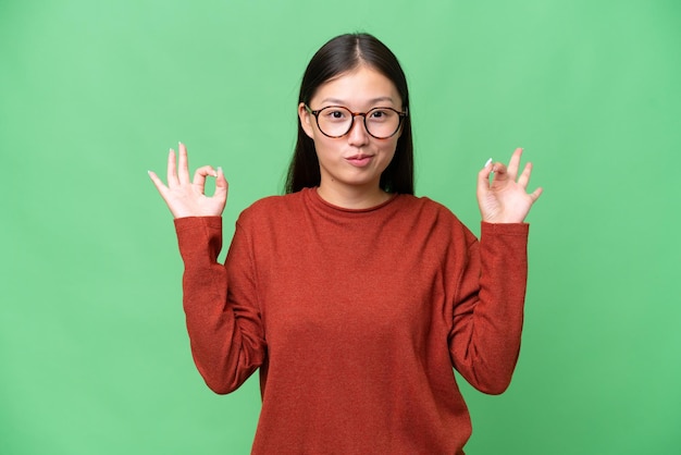 고립된 배경 위에 기침을 많이 하는 젊은 아시아 여성