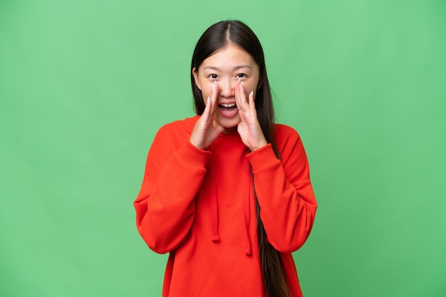 Young Asian woman over isolated background holding copyspace imaginary on the palm to insert an ad