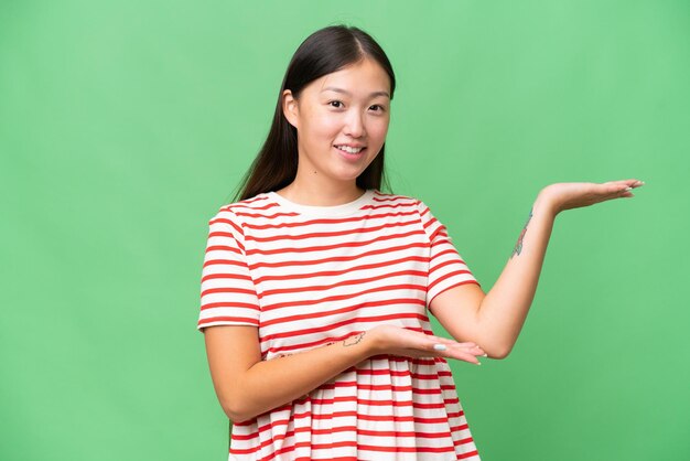 Photo young asian woman over isolated background looking side