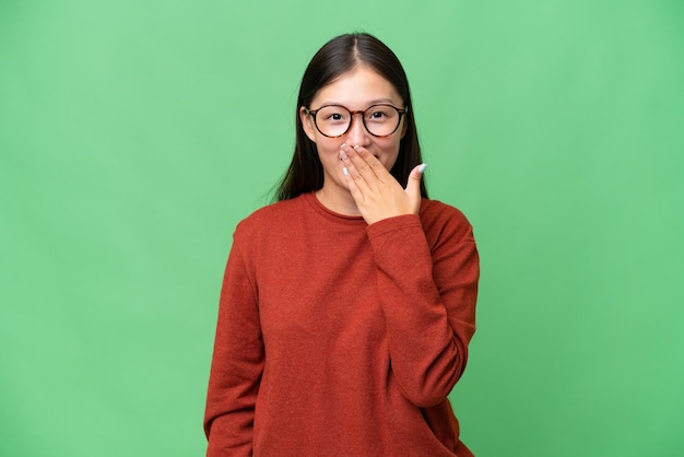 Young Asian woman over isolated background making stop gesture with her hand to stop an act