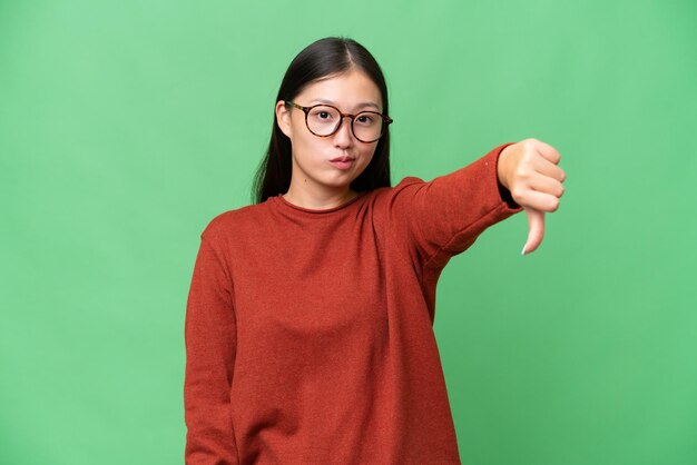 Young Asian woman over isolated background with sad expression