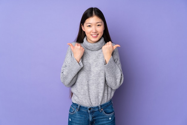 Young asian woman over isolated background with thumbs up gesture and smiling